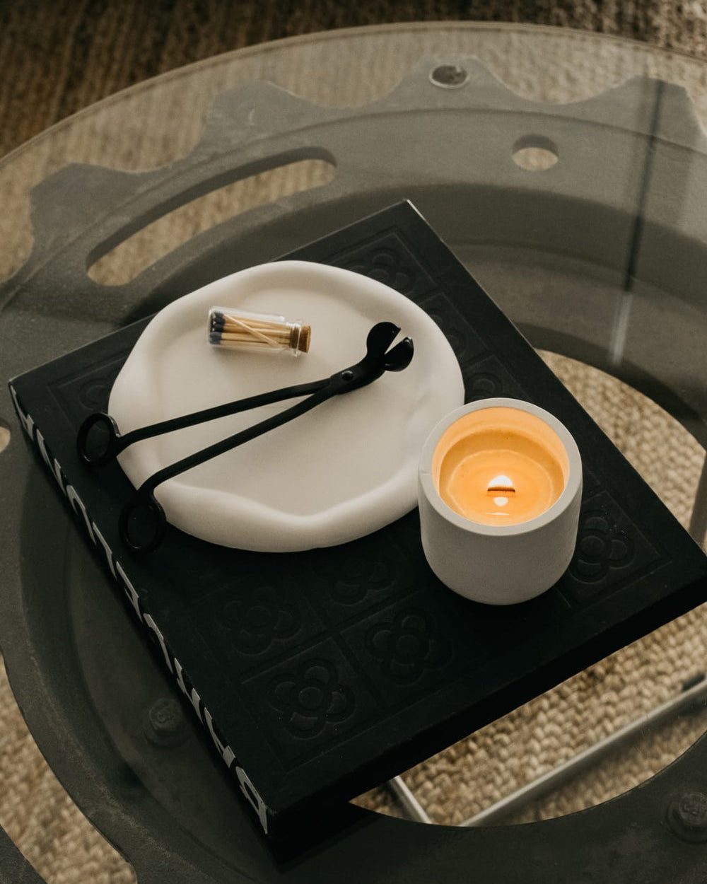 Candle and decorative items on a black book with a textured surface