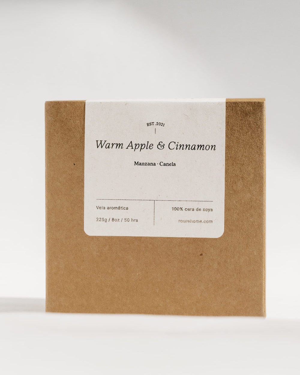 A square kraft paper box with a white label reading 'Warm Apple & Cinnamon' and 'Mazatlan, Mexico' on a clean white background.