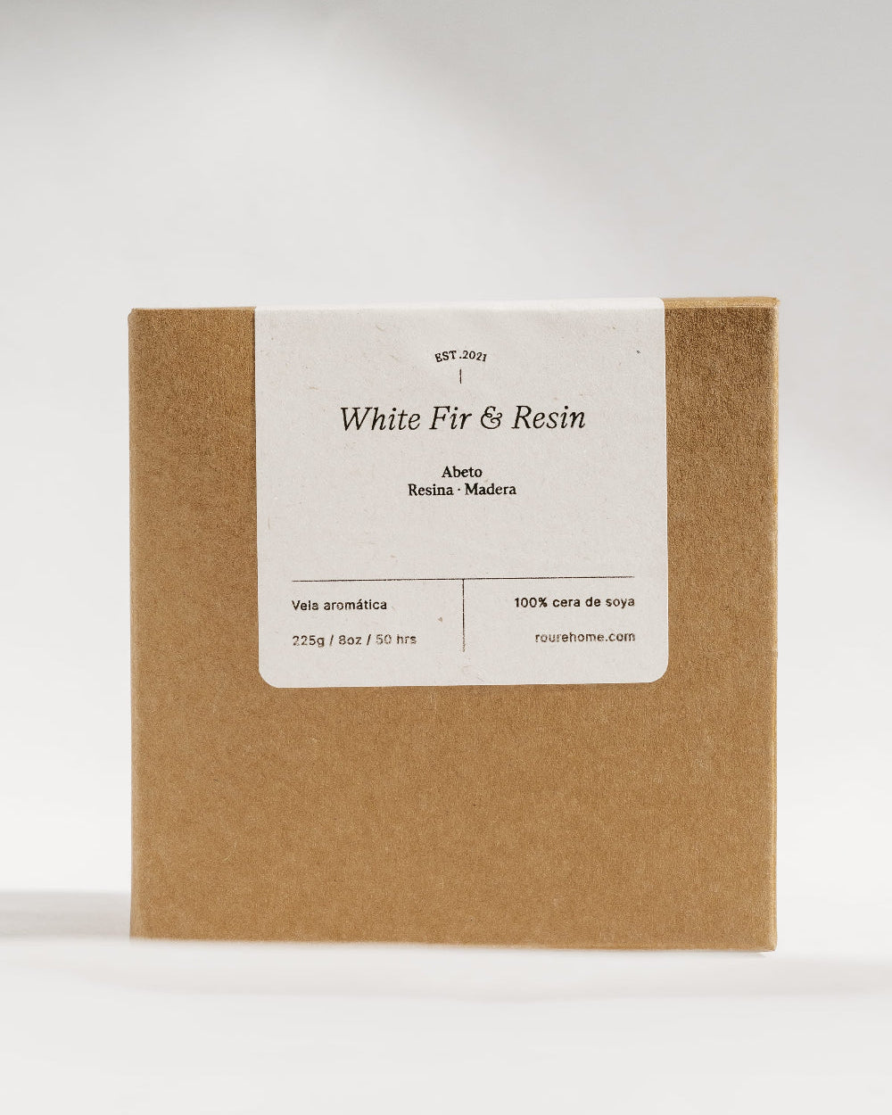 A square kraft paper box with a white label reading 'White Fir & Resin' and smaller text below, photographed against a light gray studio background.