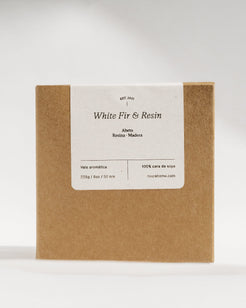 A square kraft paper box with a white label reading 'White Fir & Resin' and smaller text below, photographed against a light gray studio background.