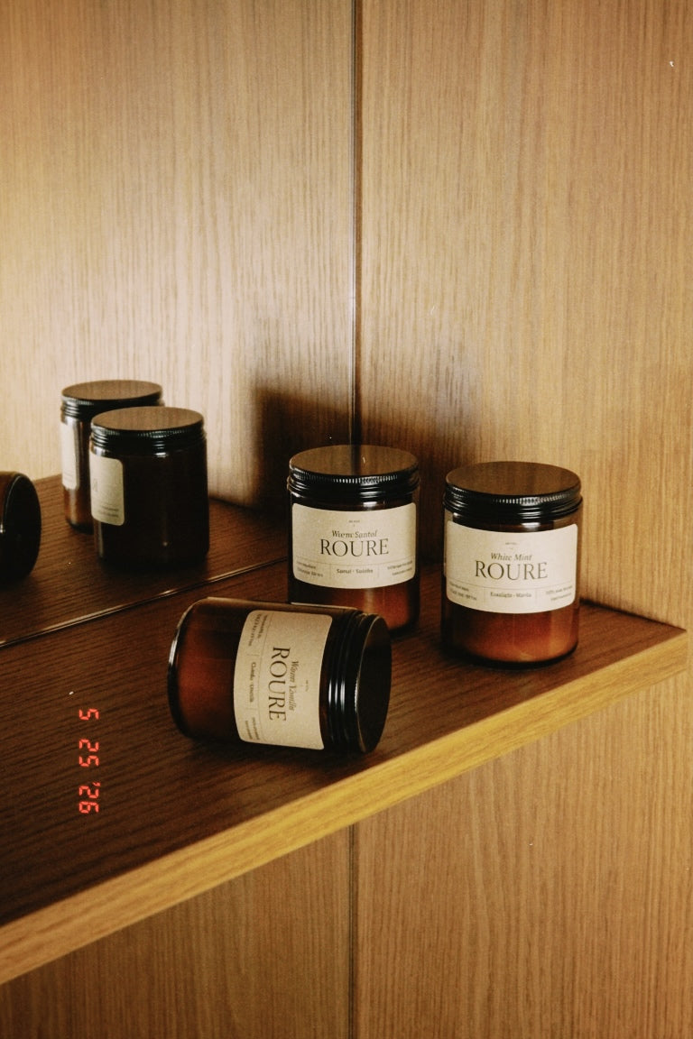 Candles with 'Roure' label on a wooden shelf
