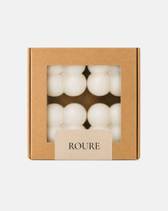 Box of white candles with 'ROURE' branding on a light gray background